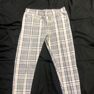 White, black, and pink plaid pants with two zippers in the front.